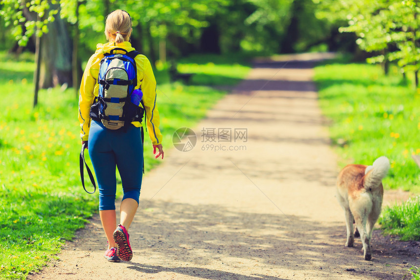 女跑者与狗一起在公园中跑步图片