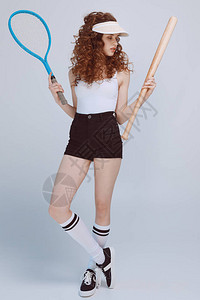 穿着帽子的漂亮的年轻时装女孩拿着网球图片