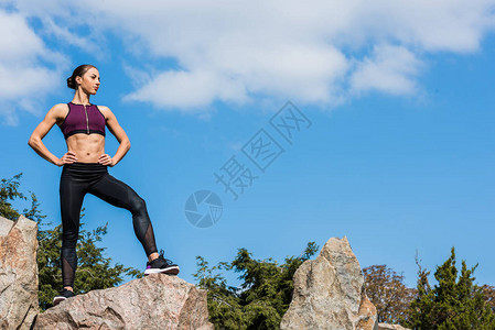 站在岩石上站着的年轻健康女图片