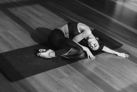 穿运动服睡瑜伽垫子的年轻女运动图片