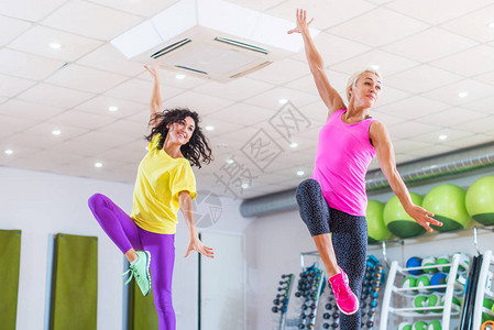 两名青年运动妇女在健身工作室舞蹈做心血管运动平衡与协调图片