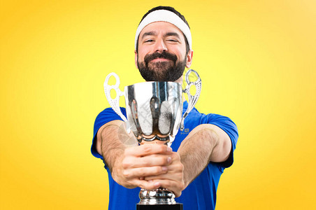 有趣的运动员拿着一个奖杯在丰富背景图片