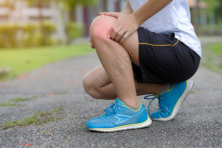 腿受伤在训练期间肌肉疼痛的年轻体健女子图片