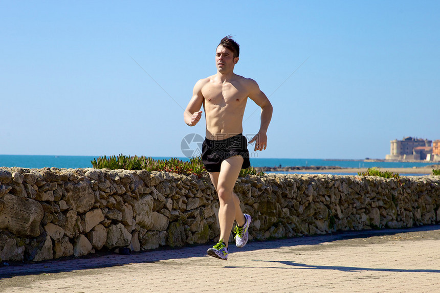 在意大利海洋和城堡前慢跑的英俊肌图片