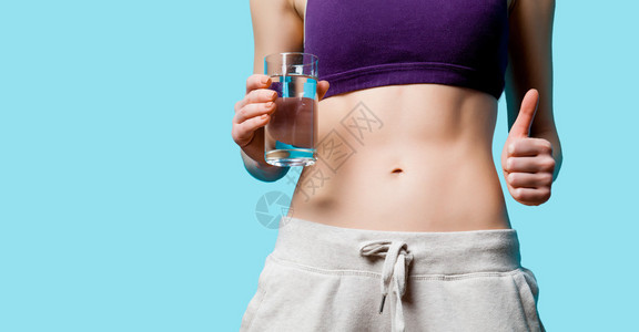 蓝色背景在体重减瘦后用水杯向图片