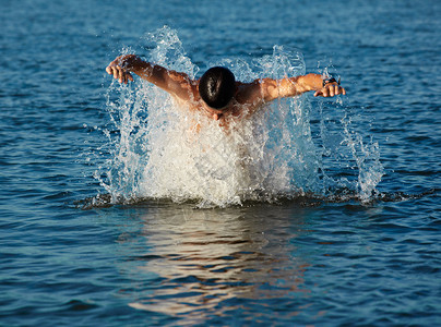 人类游泳者从水中跳出来图片