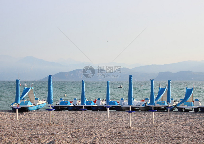 早上空荡的海滩上的水循环和遮阳伞图片