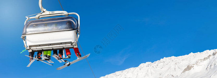 滑雪者和滑雪板滑雪者在滑雪缆车上反对清澈的蓝天文本的空白间图片