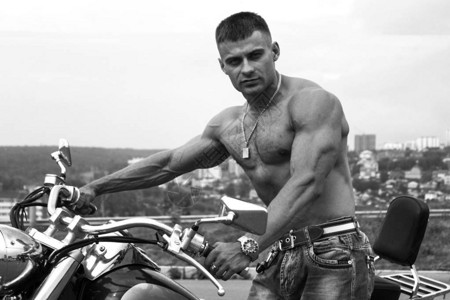 运动肌肉男摩托车旁图片