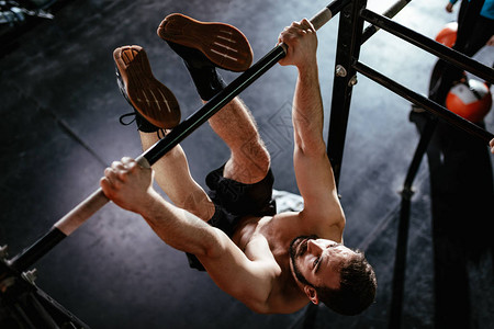 强壮的年轻肌肉男在健身房练脚图片