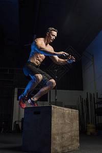 穿短裤显示肌肉身体和六包腹肌的深黑卫体操中跳箱式跳跃运图片