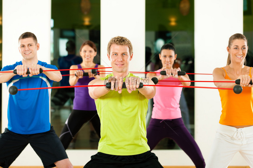 五人组用flexibar锻炼以加强健身房或健身俱乐图片