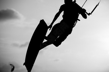 冲浪者在日落时用背光拍风筝时图片