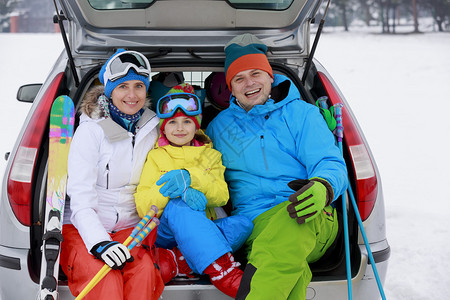 冬天滑雪旅行带滑雪设备的家庭准备图片