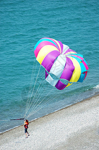 在蓝色海的多彩姿的降落伞图片