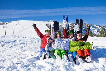 坐在雪上欢喜的朋友们举起手来图片