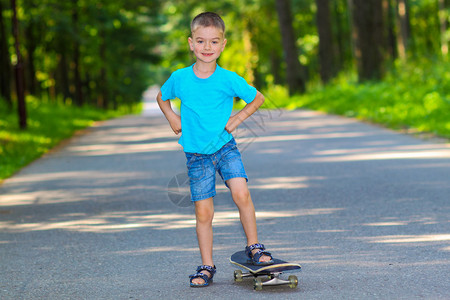 滑板的小男孩小男孩在户外玩滑板很开心小男孩在滑图片
