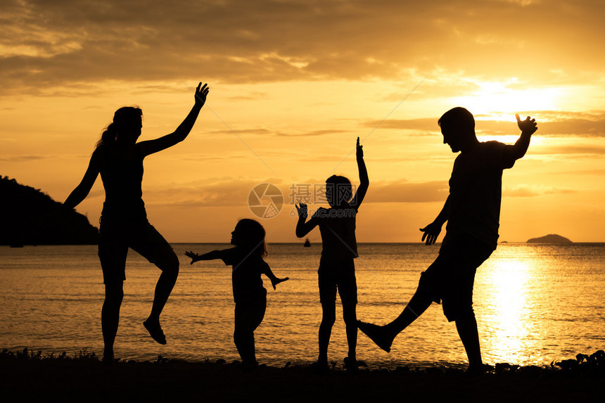 日落时在海滩上跳舞的幸福家庭休眠会图片
