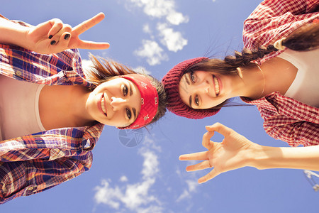 穿着时装牛仔裤短裤衫格子衬衫帽子的两名黑人少女朋友在公图片