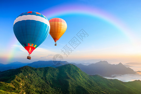 羽球五颜六色的热气球飞过山背景