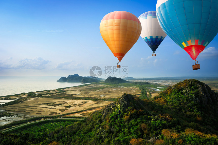 热气球漂浮在海上山的天空图片