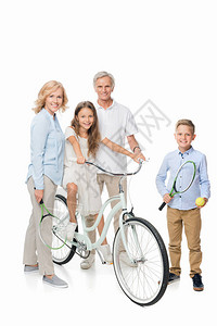 快乐的祖父母和孩子用自行车和网球拍打图片