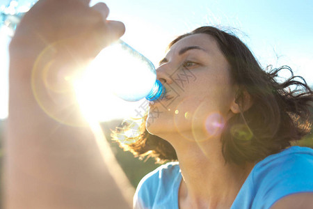 一个女人在山顶喝水女孩解渴疲惫的游客用塑料瓶喝饮料黑发女人嘴图片