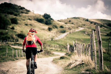 山地车手骑在秋季山区的自行车单轨小道上在乡村公路或单轨上骑山地车的男子骑手美丽的励志景观中的健背景图片