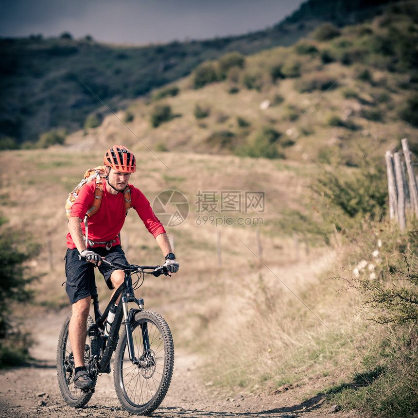 山地车手骑在秋季山区的自行车单轨小道上在乡村公路或单轨上骑山地车的男子骑手美丽的励志景观中的运动健图片