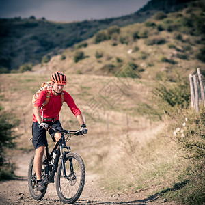 山地车手骑在秋季山区的自行车单轨小道上在乡村公路或单轨上骑山地车的男子骑手美丽的励志景观中的运动健背景图片