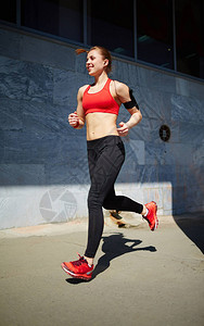 年轻女运动员在街上跑步背景图片