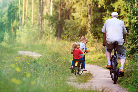 活跃的老人与孙子在大自然中骑自行图片