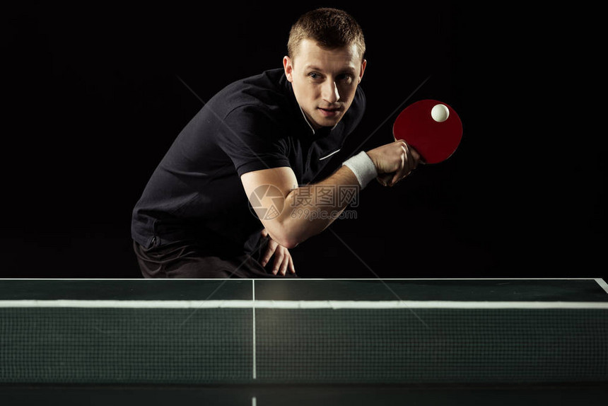专注于打乒乓球的网球运动员与黑色隔离图片