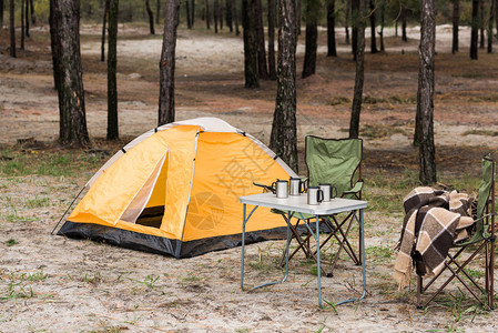 有桌椅的野营帐篷站在林里图片