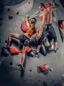 在攀岩墙上攀爬的运动型男女图片
