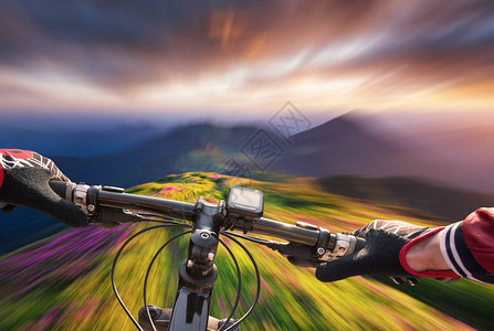 日落时骑着自行车在山谷快速骑车运动和图片