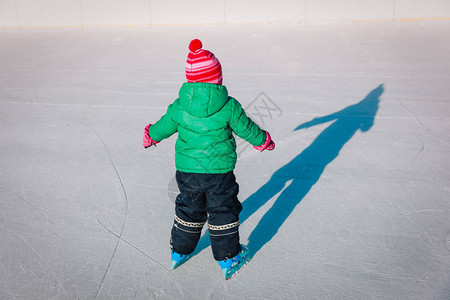 小女孩在冬天的大自然中学习滑冰图片