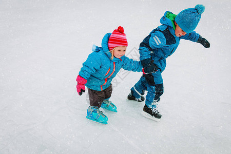 男孩和女孩在冬季雪中一起滑冰孩子们图片