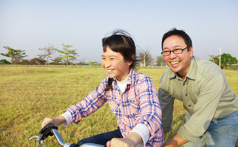 快乐的父亲教孩子骑自行车图片