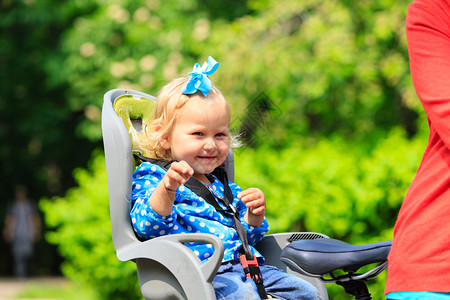 小女孩骑自行车座椅在城里和母亲图片
