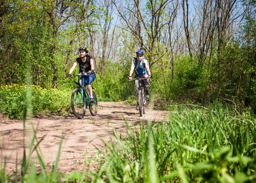 春天森林里骑自行车的情侣图片