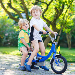 两个小男孩一起骑自行车孩子们玩得开心快乐孩子们在户外享受积图片