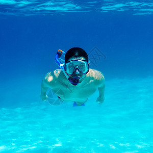 戴面具在清水中浮潜的男人图片