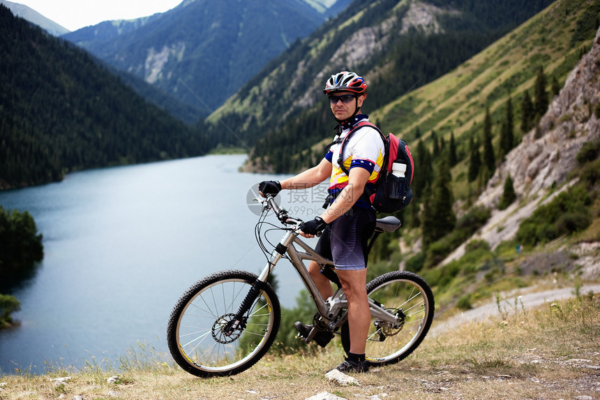在一个美丽的山湖旁边的骑自行车者图片