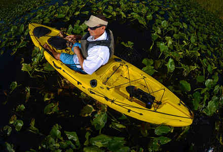 黄色皮划艇在睡莲叶中钓鱼的男子皮划艇图片