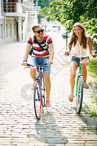 快乐的少女和男人在公园休闲骑图片