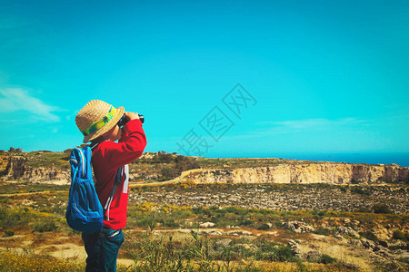 带着双筒望远镜在山上远足的小男图片