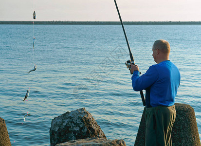 一个人在钓竿上钓到鱼图片