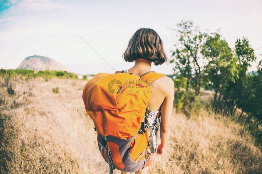 一个女人背着包旅行女孩爬上了山顶褐发女图片