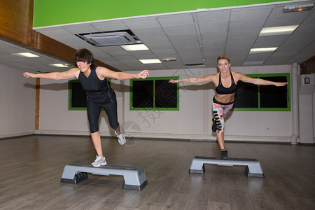 两名健身妇女在体操中进行职级有氧图片
